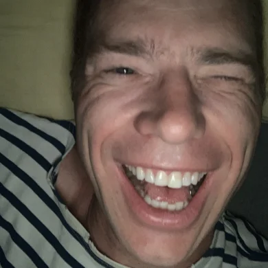 Ramp smiling widely and laughing in a striped shirt
