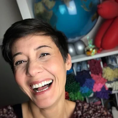 Ramp smiling widely in front of a globe and balloons.